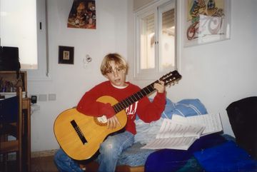 Yoav with a guitar as a child.