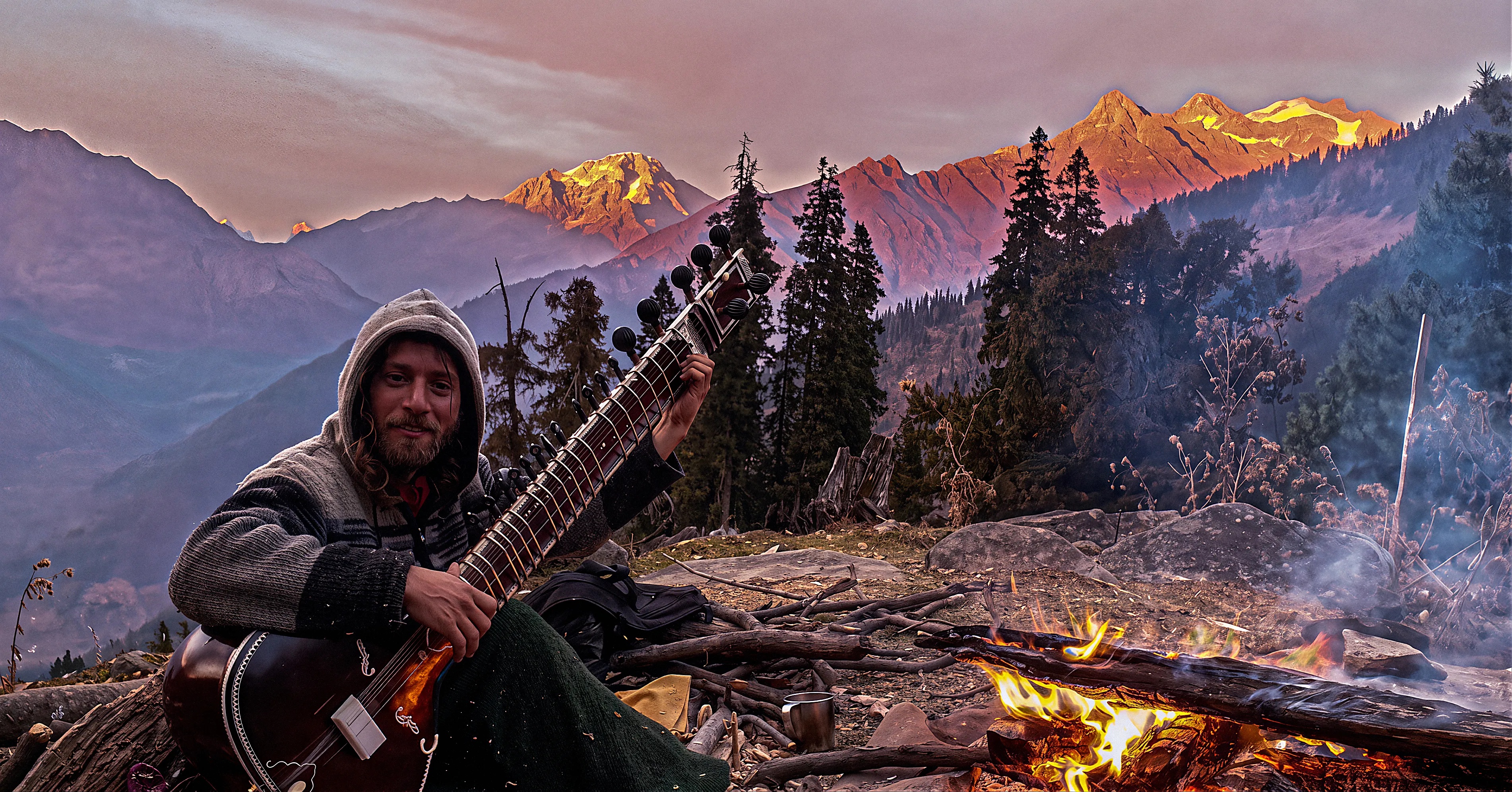 יויו מנגן בסיטאר בהרי ההימליה, בעמק פארוואטי ליד אש  בשקיעה
