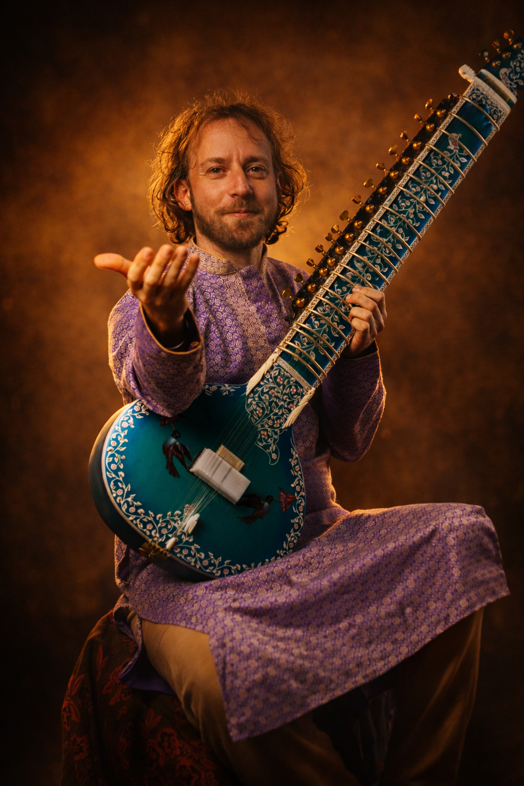 יויו סיטאר עם הסיטאר בלבוש קורטה בתאורת סטודיו.